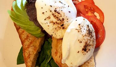 Image shows poached egg on toast with avocado, lettue & tomato.