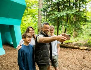 An image of a family standing in front of Peep the Hare taking a selfie.