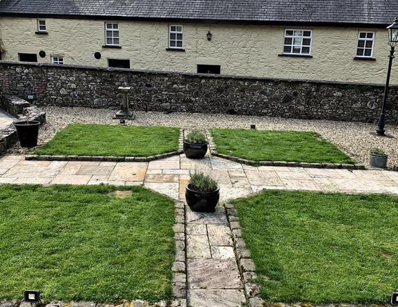 Image shows back of property with landscaped garden area