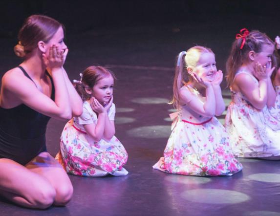Young girls on stage with dance teacher