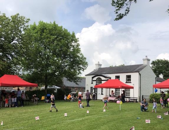 Picture of the Ballance House and activities and people on the lawn