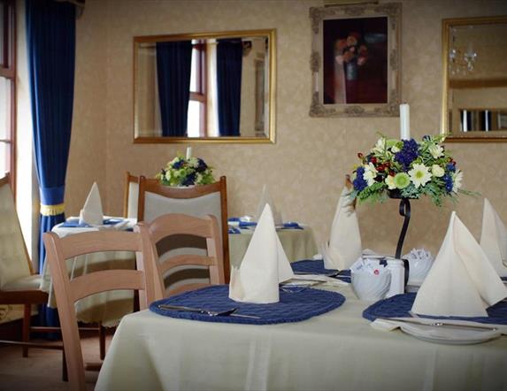 Image shows breakfast room with tables and chairs