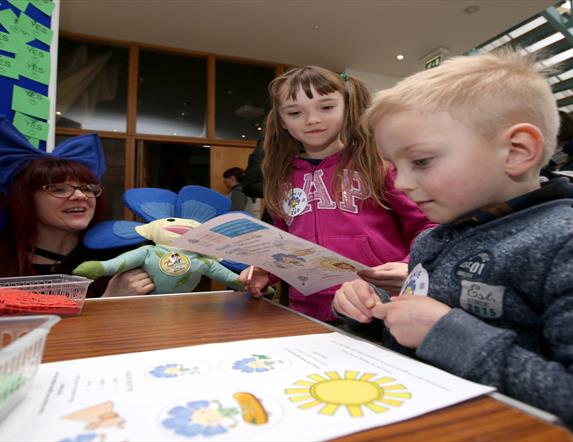 Image shows children sitting at a table looking at the Flaxie Trail