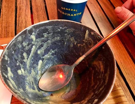 Image is of an empty plate of food and a coffee cup from General Merchants cafe