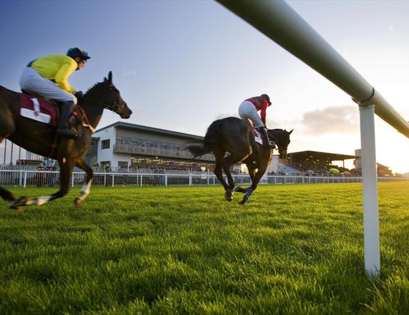 Horses with jockeys racing