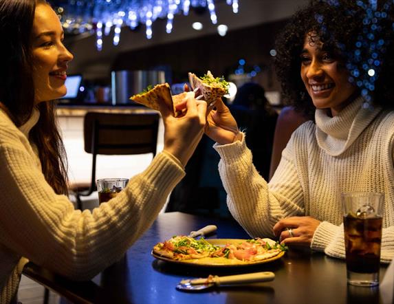 Two girls enjoying pizza at Little Wing's, Lisburn