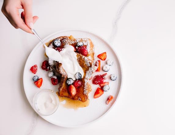 Image is of French toast, strawberries and cream at Mimi's Speciality Coffee
