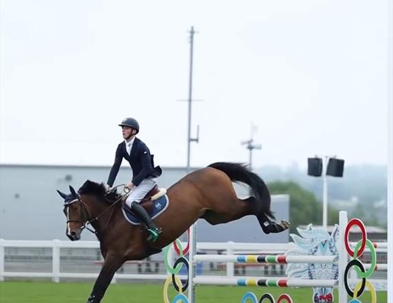 Image is of rider and horse show jumping