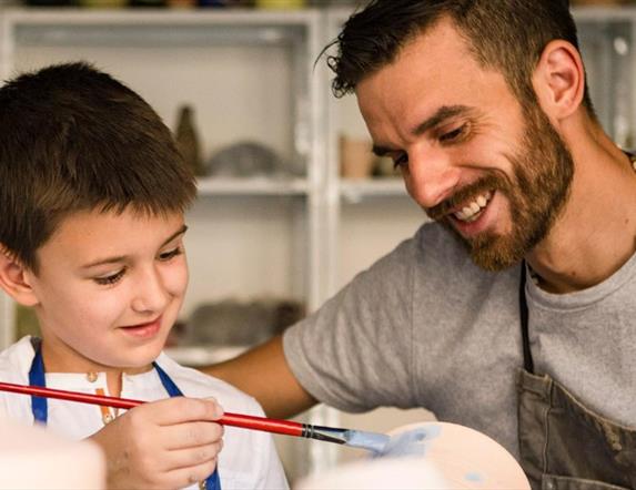 Father and son painting in a pottery class