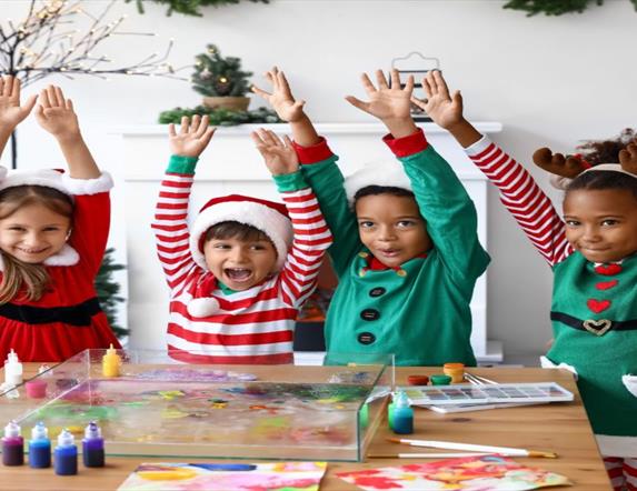Image is of children dressed in Christmas outfits