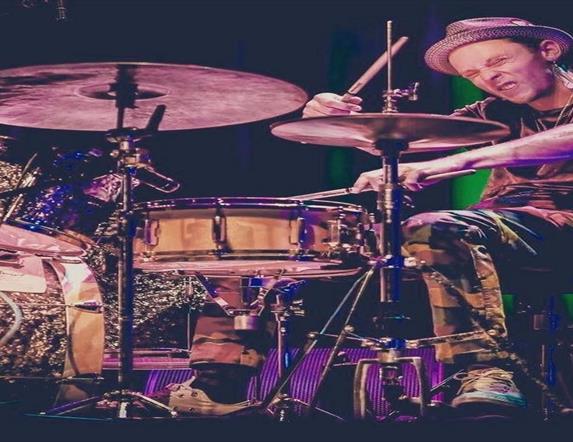 Image is of a man playing the drums
