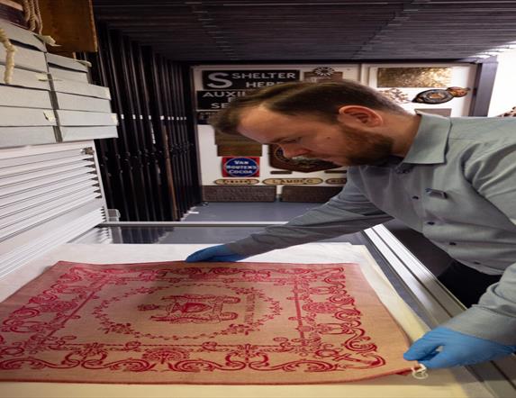 Image history curator examining an artefact