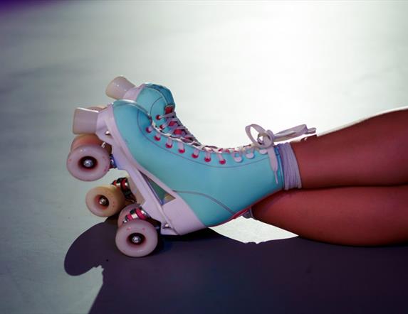 Image is of a pair of blue and pink roller skates