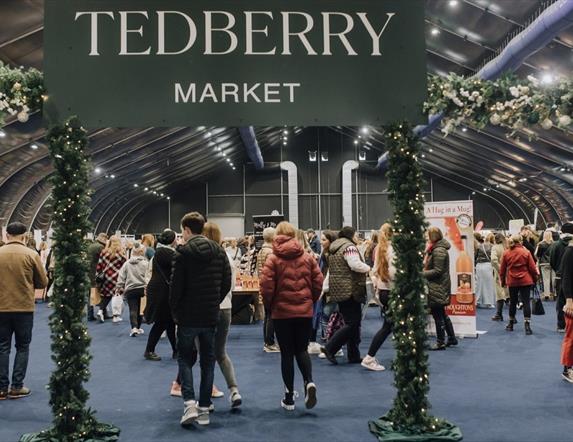 Tedberry Market sign with visitors and traders