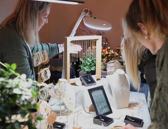 Trader showing customers her jewellery.