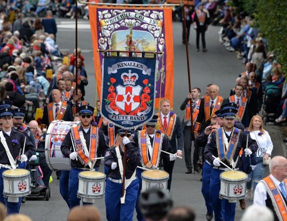 Image is of a Twelfth of July parade with spectators