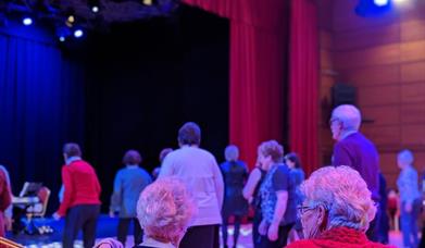 Tea dance participants seated and dancing
