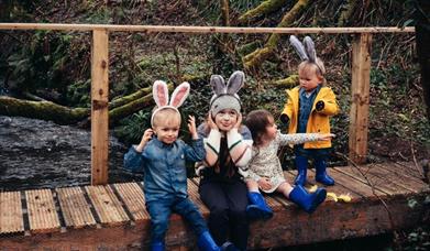 4 children sitting on a wall dressed in Easter costumes