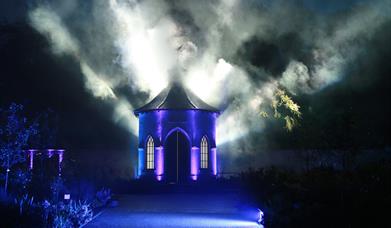 Image is of a Halloween scene in the Castle grounds with lights and smoke