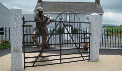 Sculpture of Harry Ferguson looking over his gate