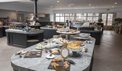 Image shows a creative display of food showing a selection of deserts on a grey marble worktop