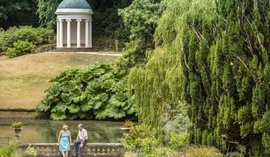 Picture of a couple sitting on a bridge with Lady Alice's Temple in the background