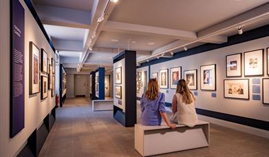 Visitors sitting at the Life Through A Royal Lense Exhibition