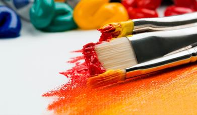 Image shows a variety of paint brush sizes and paint