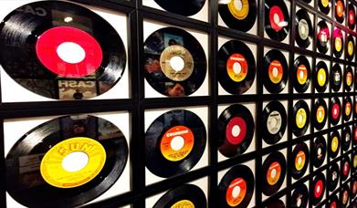 Image is a wall of various vinyl records