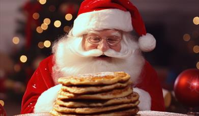 Image is of Santa Claus eating some pancakes