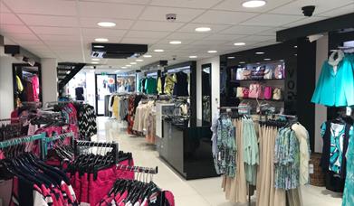 Inside Vogue Lisburn, clothing racks and handbags