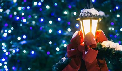 Christmas lights with a lantern wrapped in a red ribbon