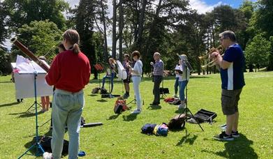 People in the orchestra playing in a park