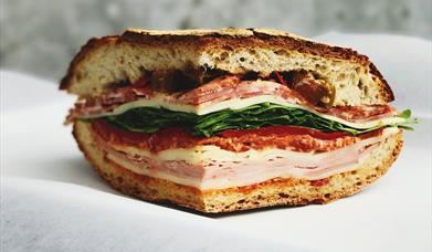 Image shows a sandwich with ham, chicken, bacon lettuce & tomato