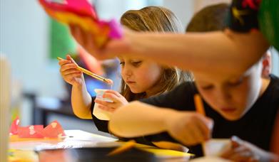 Two children working on a arts programme