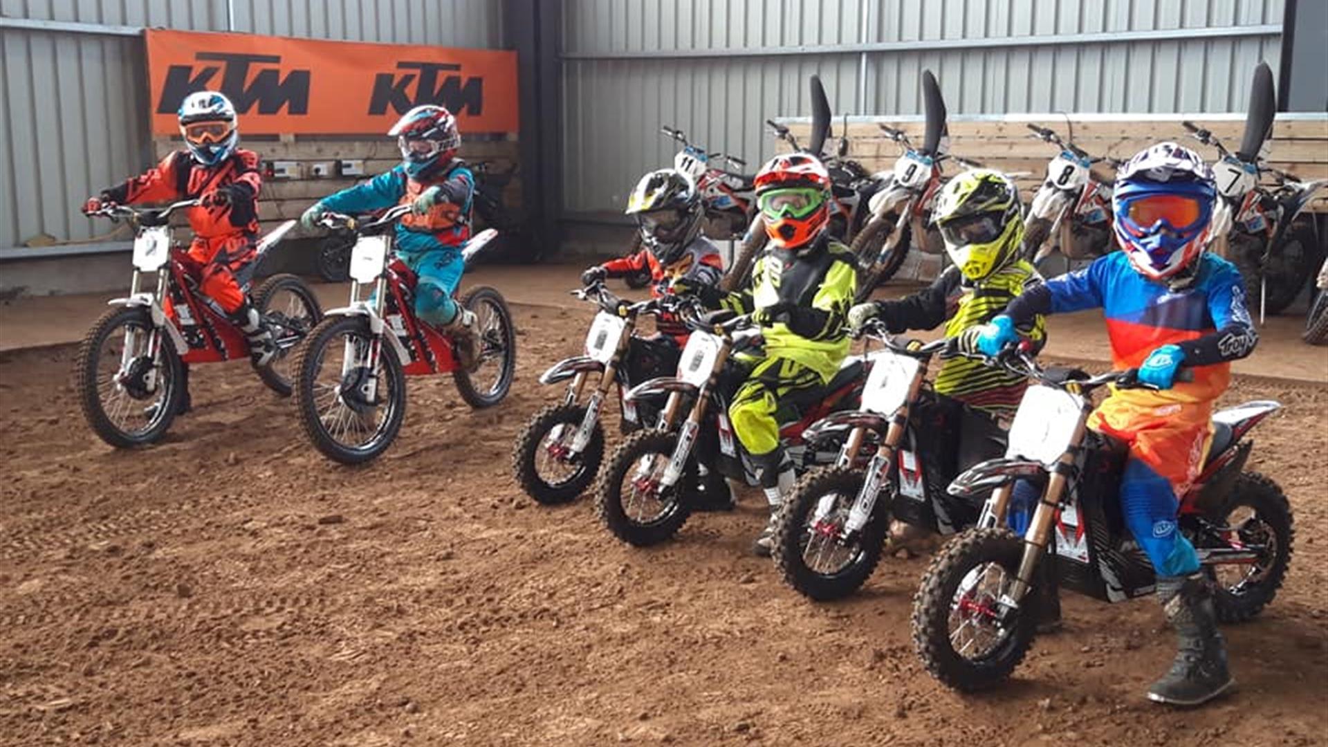 Image shows row of children on mini motorcycles