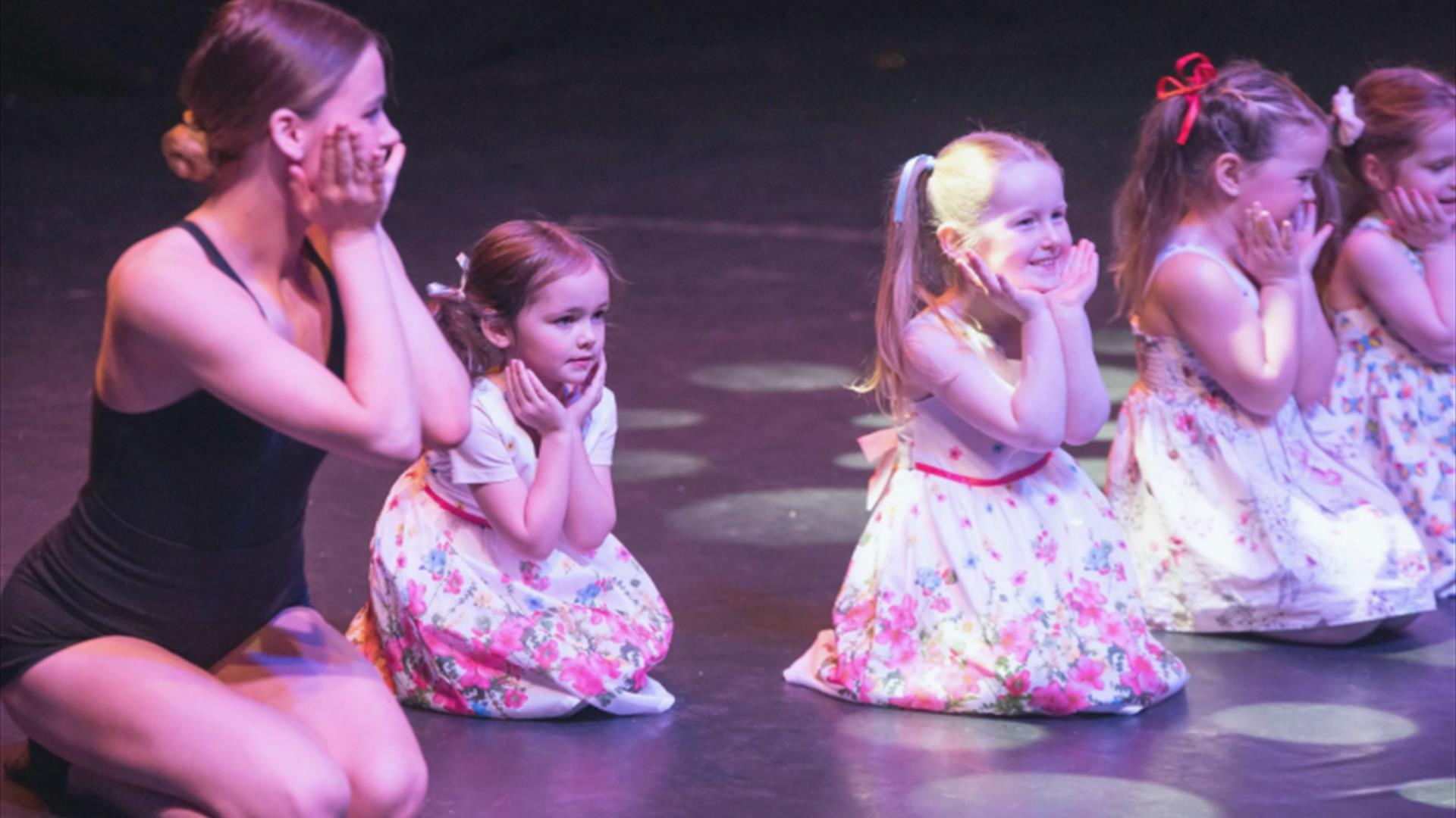Young girls on stage with dance teacher