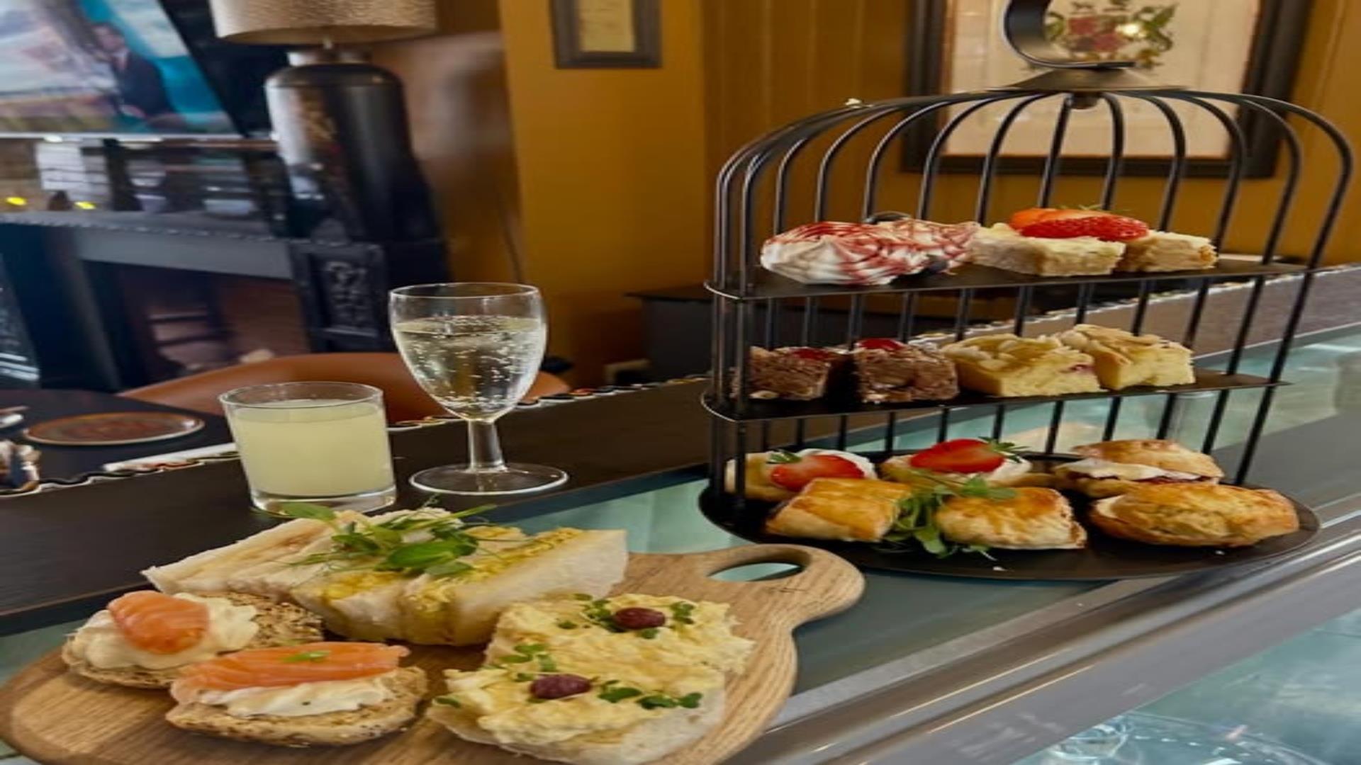 Image of afternoon tea, sandwiches, scones and drinks.