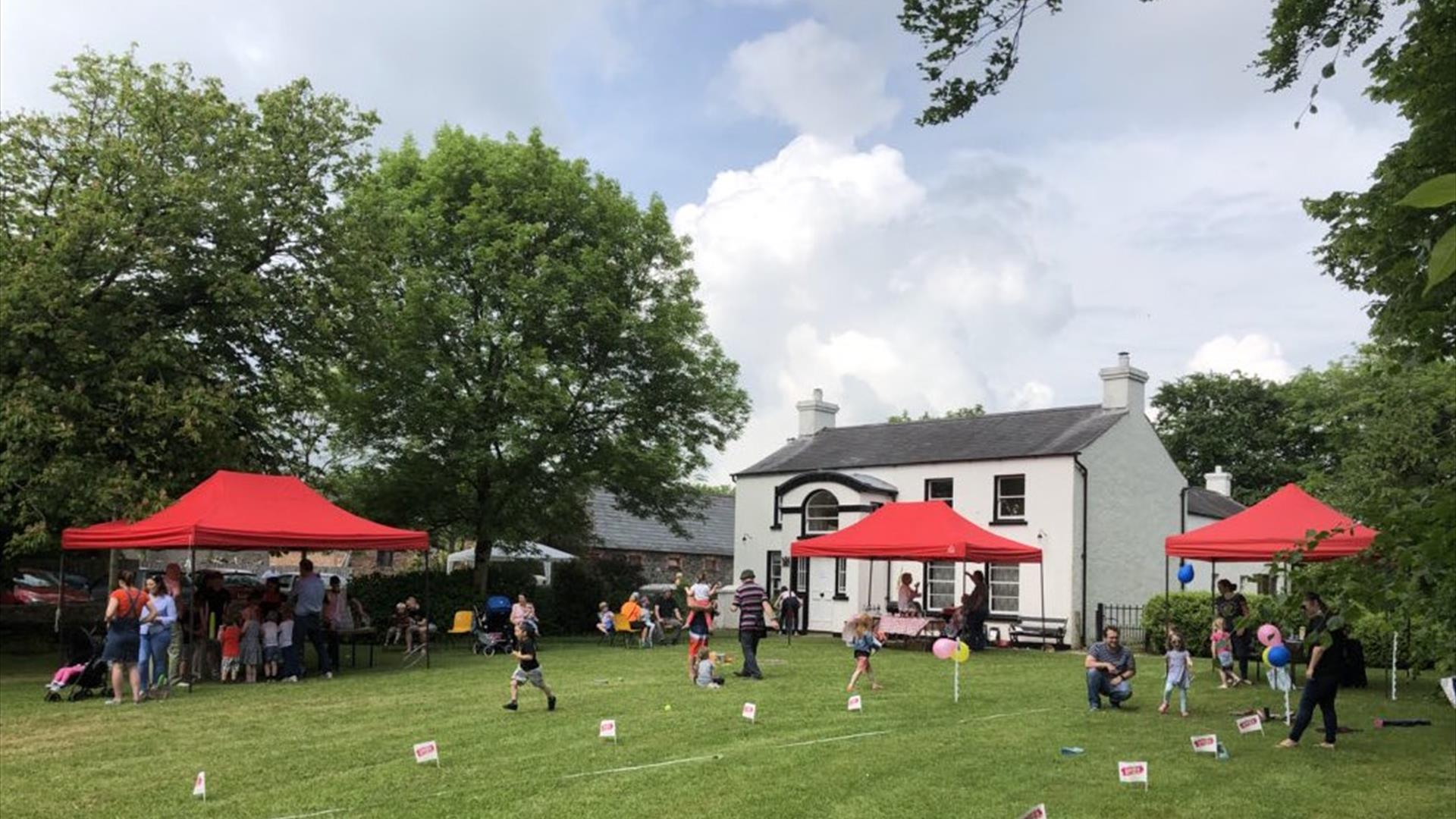 Picture of the Ballance House and activities and people on the lawn