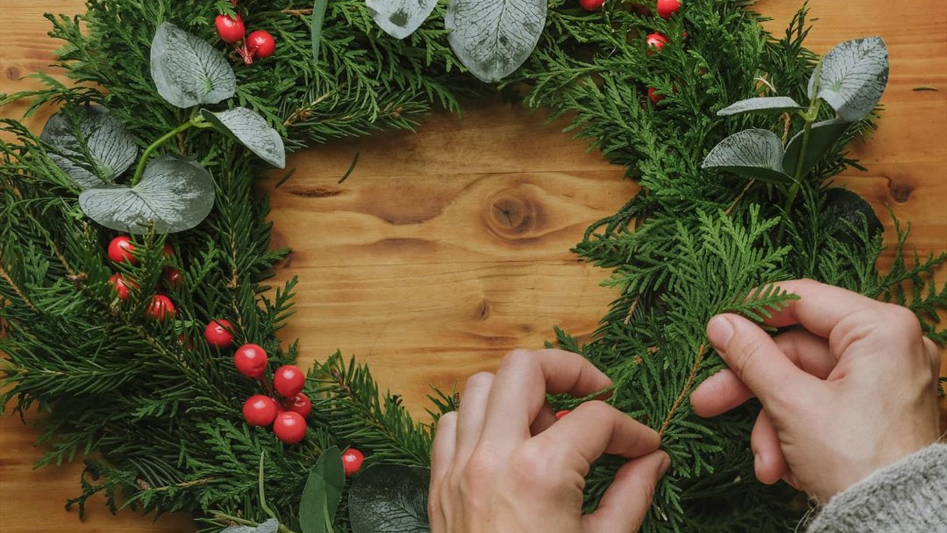 Image is of someone making a Christmas wreath