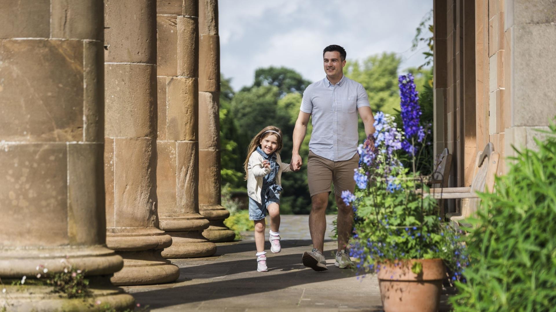 Image shows a father and daughter holding hands outside Hillsborough Castle.
