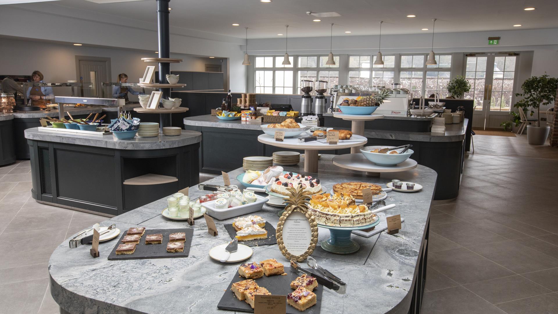 Image shows a creative display of food showing a selection of deserts on a grey marble worktop