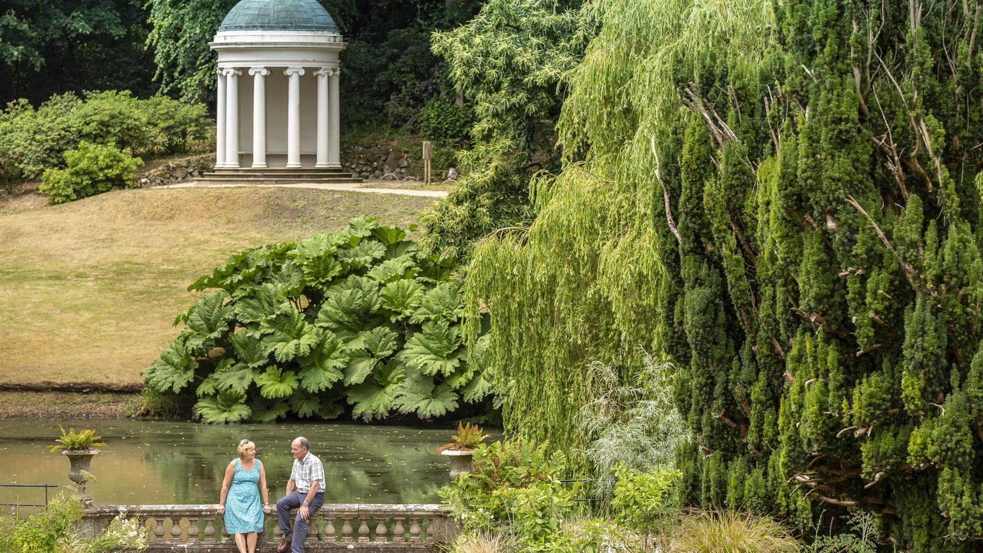 Picture of a couple sitting on a bridge with Lady Alice's Temple in the background