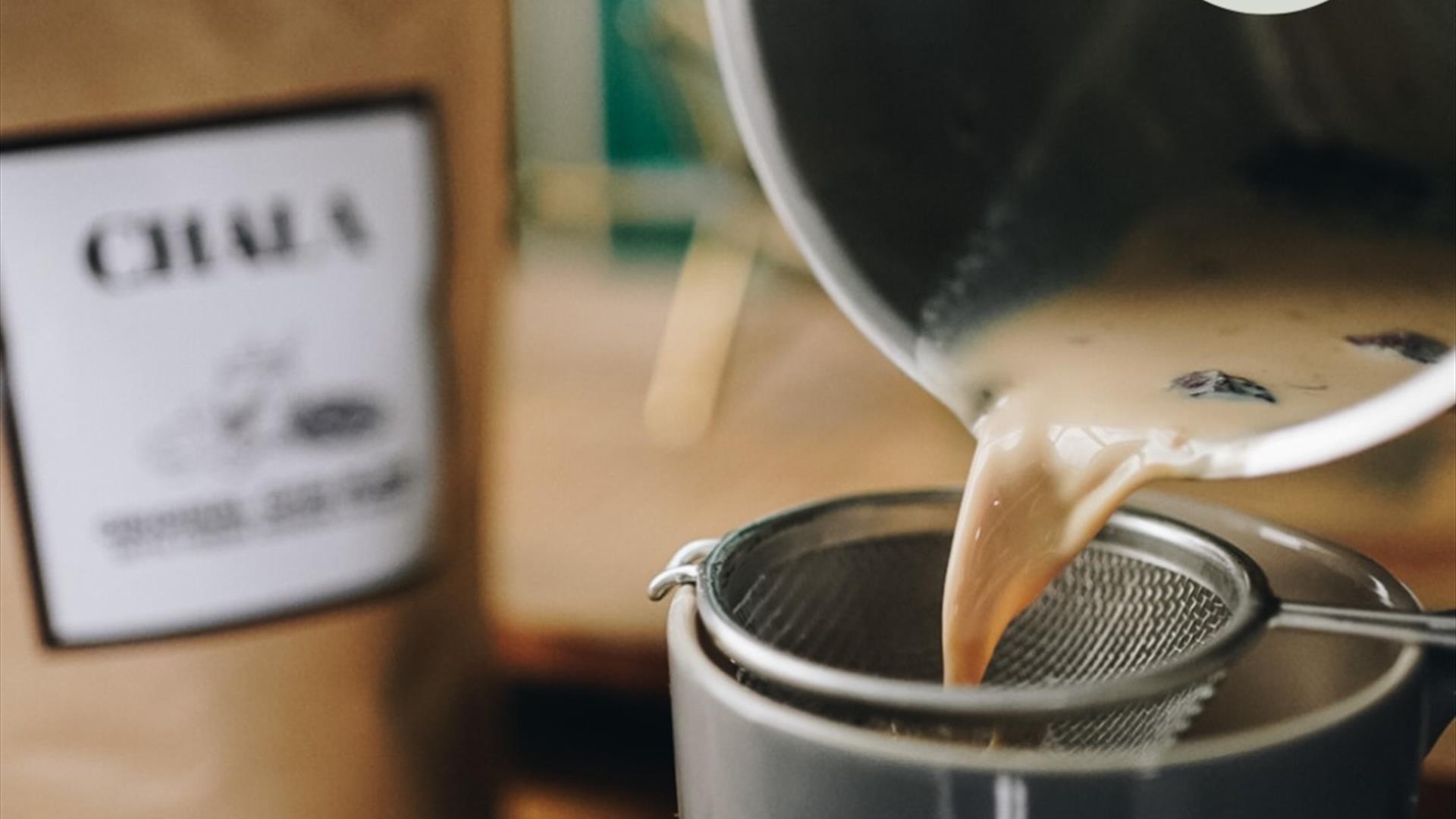 An image of Chai Tea being poured through a sieve