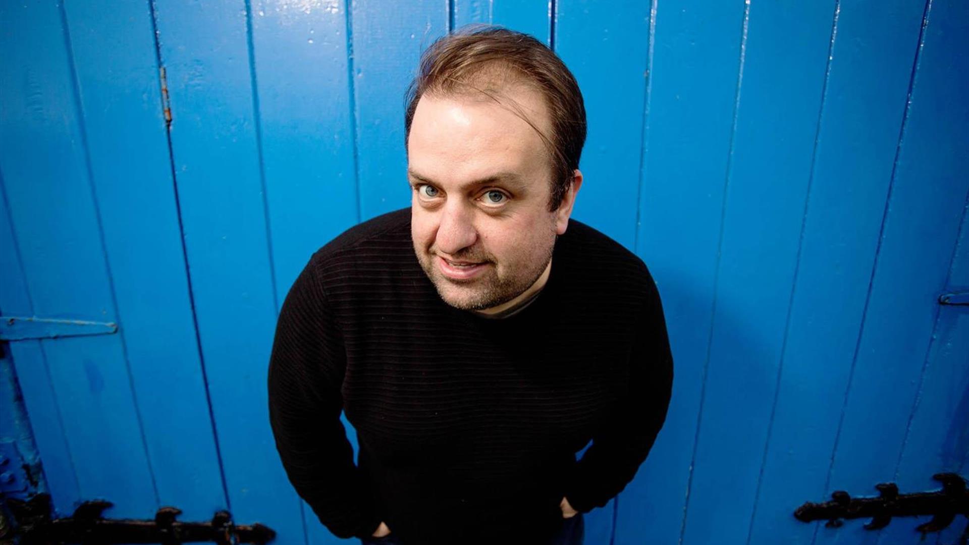 Picture of Karl Spain standing in front of a blue door