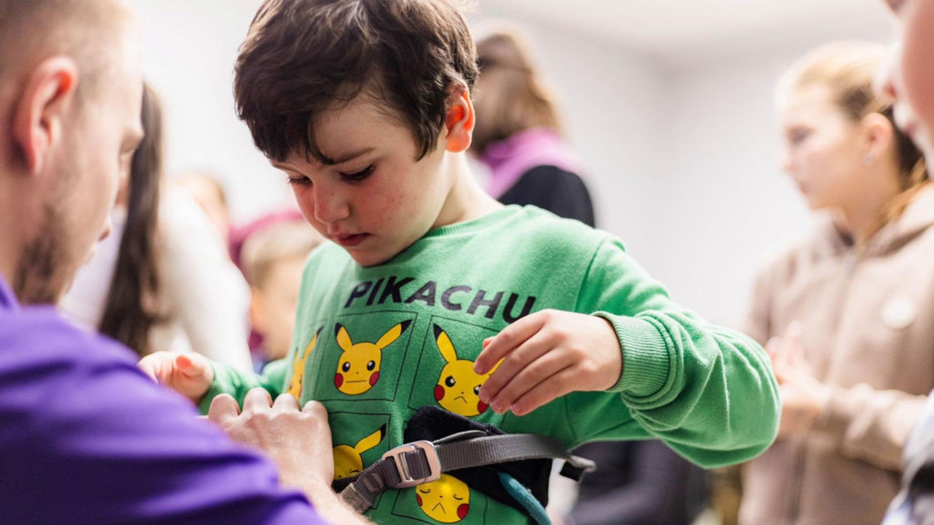 Little boy being strapped into safety harness