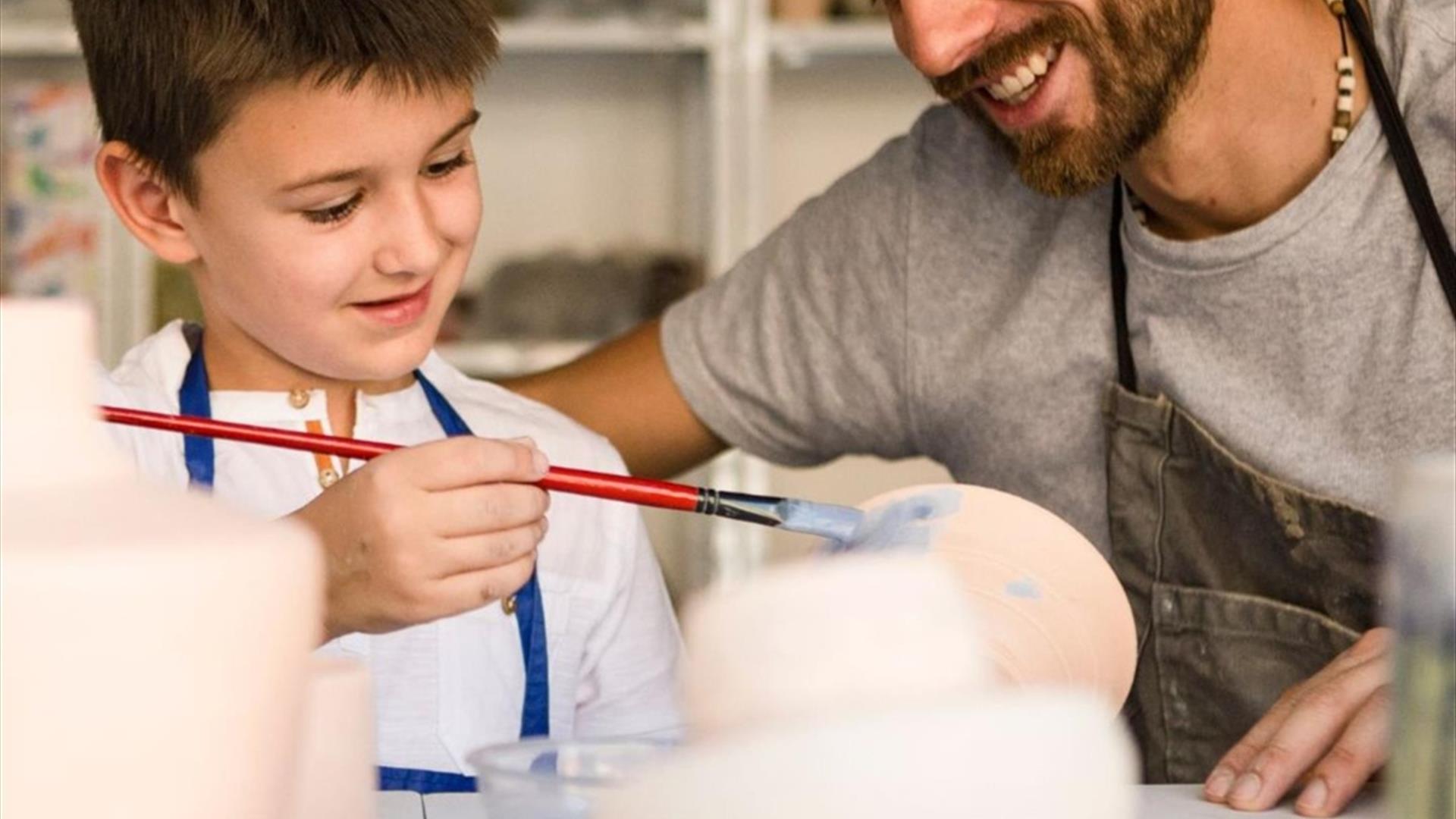 Image shows Father and Son painting pottery.