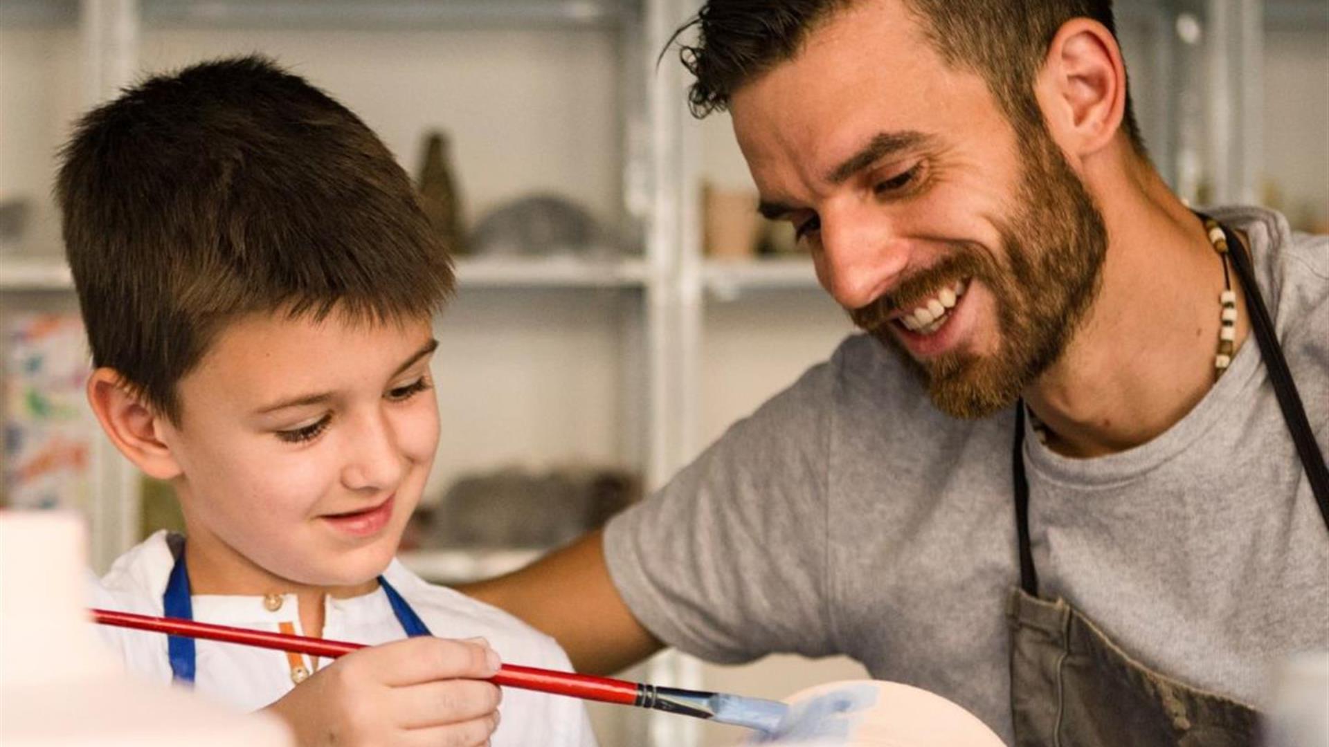 Father and son painting in a pottery class