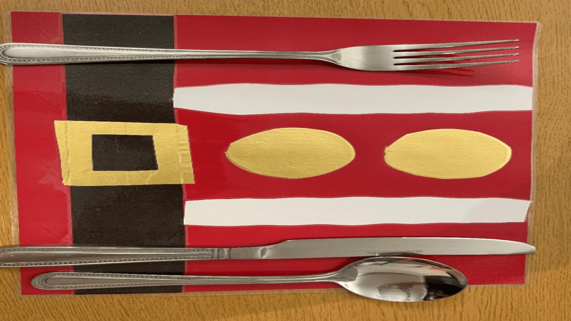 Image is of a festive place mat with cutlery