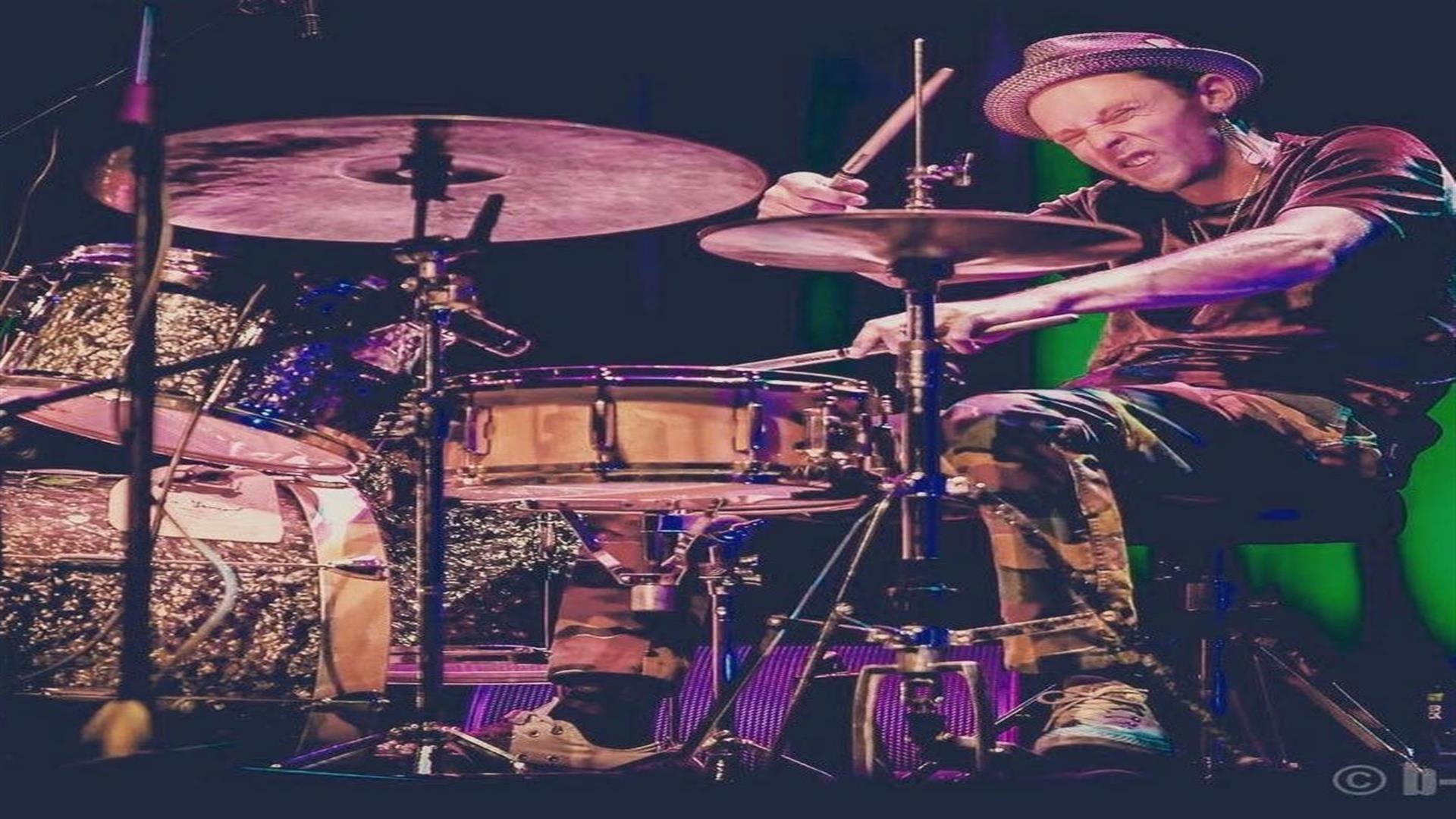 Image is of a man playing the drums